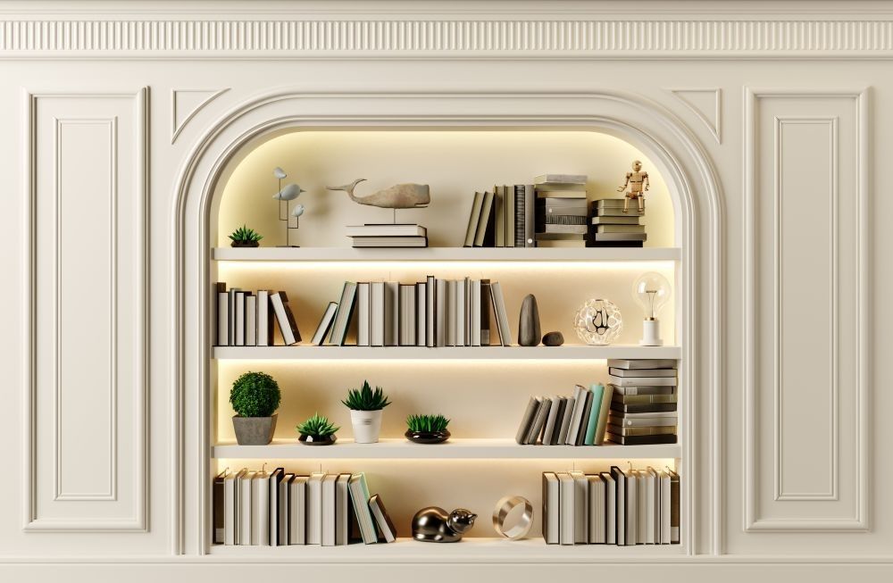Arched built-in bookshelf with books, plants, decor, and warm integrated lighting