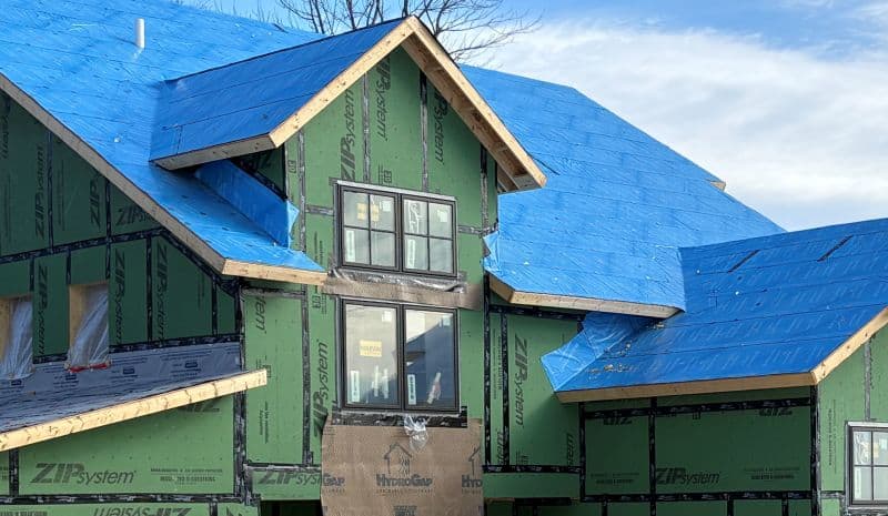 New home construction wrapped with weather barrier and roof protection