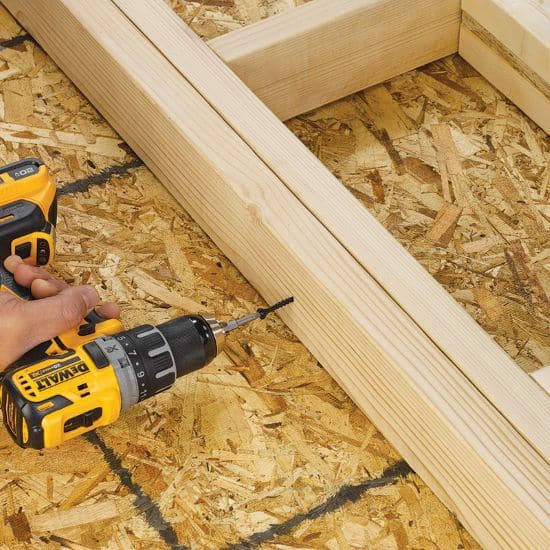 Power drill fastening lumber framing on OSB subfloor